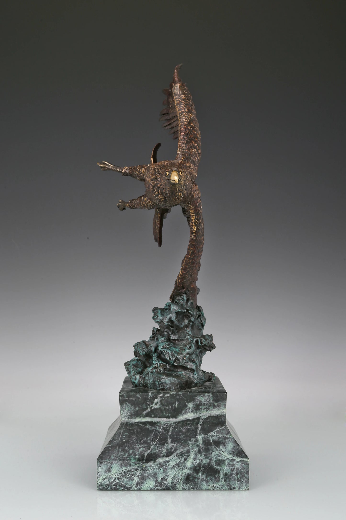 Bronze eagle sculpture with wings spread, capturing a powerful takeoff moment. A bold statue symbolizing strength, freedom, and ambition.