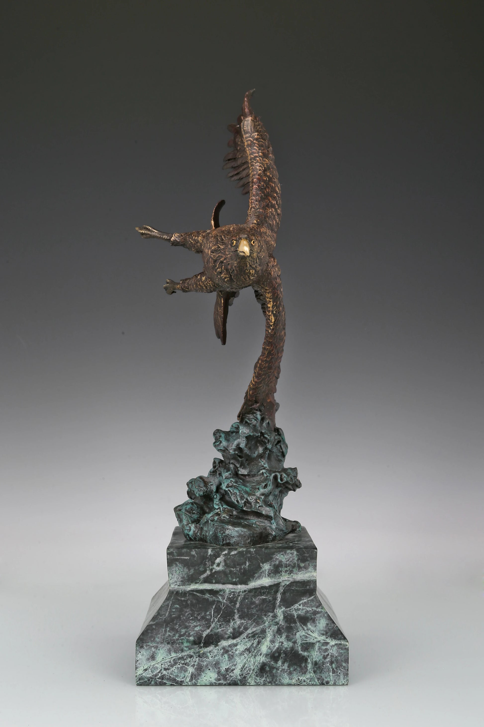 Bronze eagle sculpture with wings spread, capturing a powerful takeoff moment. A bold statue symbolizing strength, freedom, and ambition.