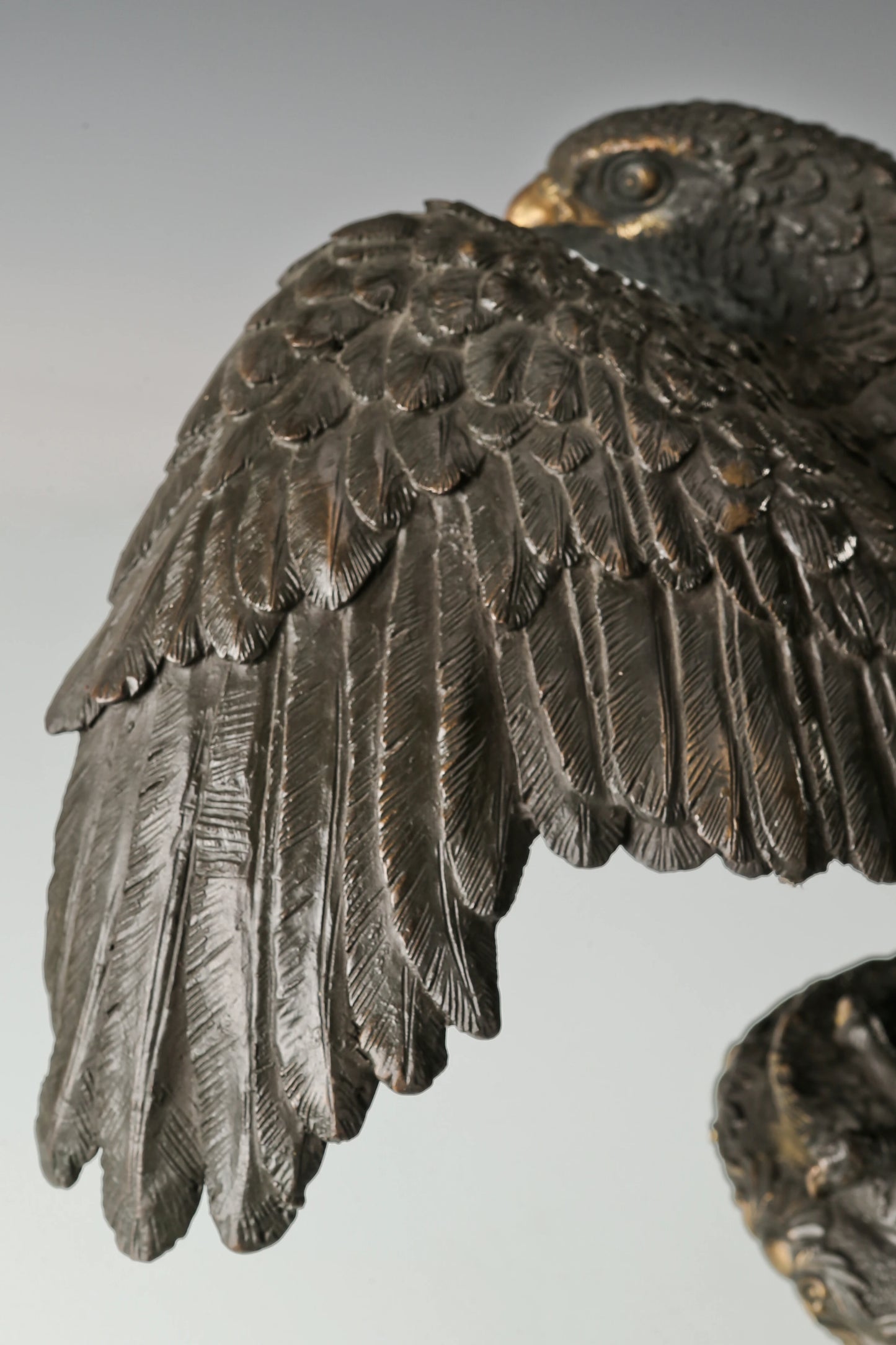 Elegant bronze eagle sculpture with ornate pedestal and detailed feathers. A refined statement piece symbolizing strength, control, and authority.