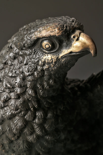 Bronze eagle statue with wings partially spread and decorative base. Classical wildlife sculpture for home decor, office, or collectors.