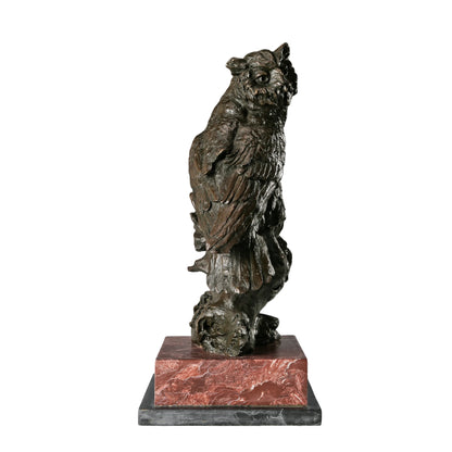 a realistic bronze owl sculpture with detailed feather textures and a striking red and black marble base. A symbol of wisdom, perfect for home, office, or library decor.