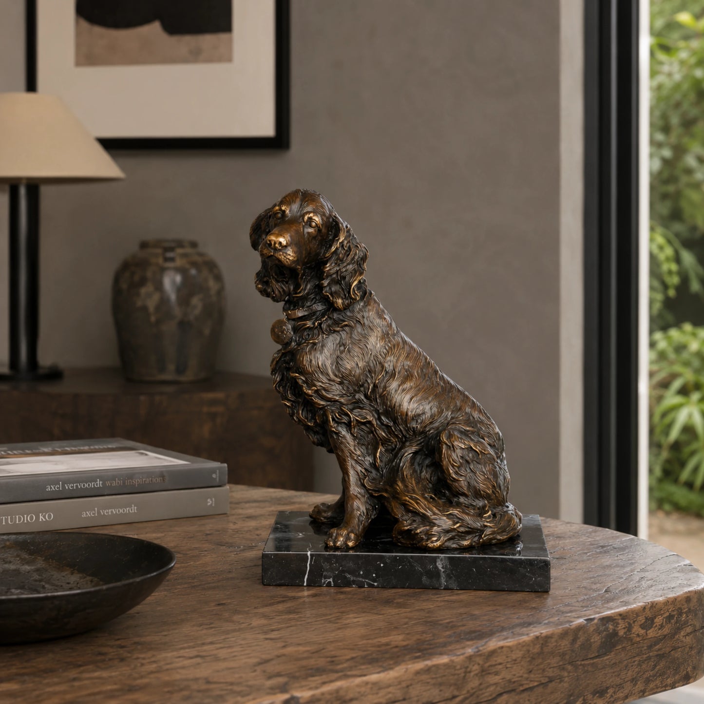 A lifelike bronze spaniel dog statue in a seated pose with its mouth open, featuring a warm patina and wavy coat for fireplace mantle or shelf decor.