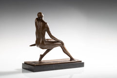 Rear angled view of bronze female figure with crossed legs and one arm resting behind her