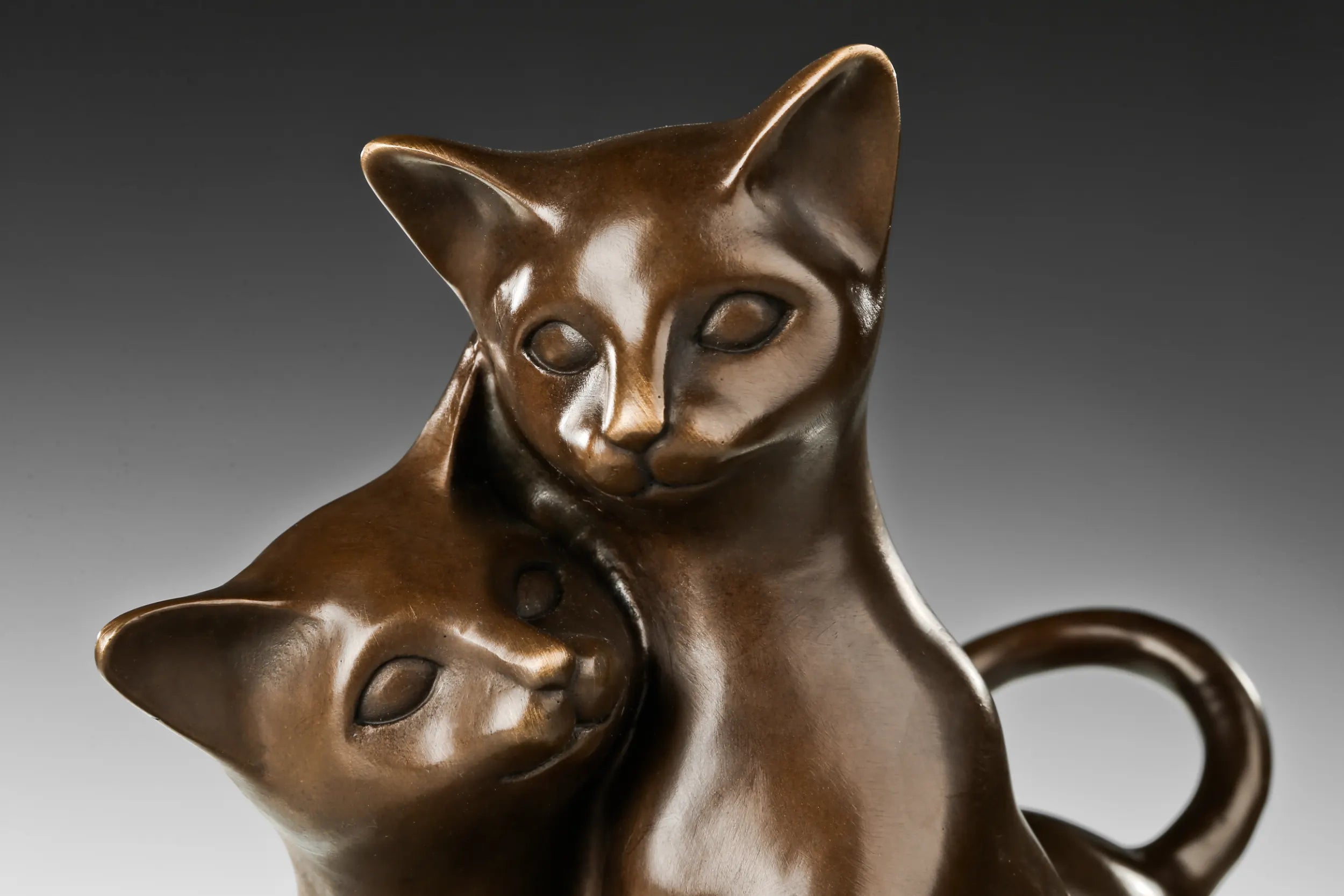 Close-up detail of two affectionate cats in bronze