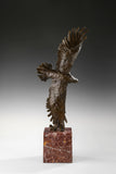 Bronze eagle sculpture over ocean waves with detailed feathers and marble base. Unique wildlife statue for home decor and collectors.