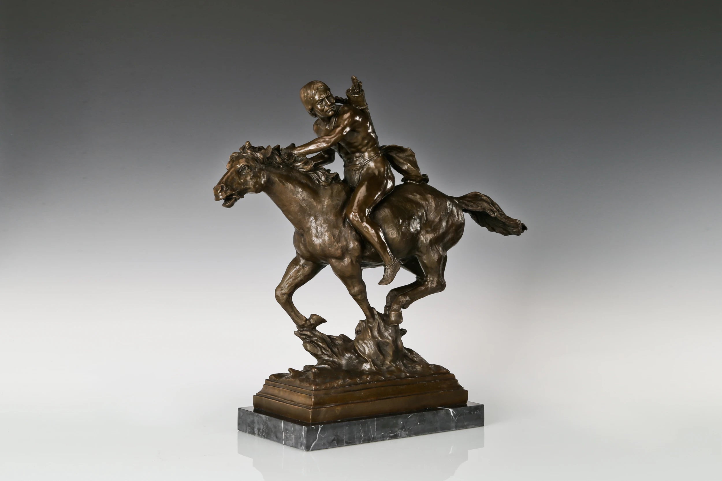 Left side view of Native American rider bronze statue on a running horse