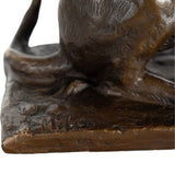 base of playful bronze cat statue with extended paw and butterfly detail