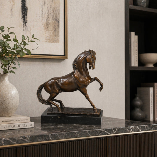 Refined prancing bronze horse sculpture with raised foreleg and flowing mane, realistic equestrian statue on black marble base, lost wax casting fine art.