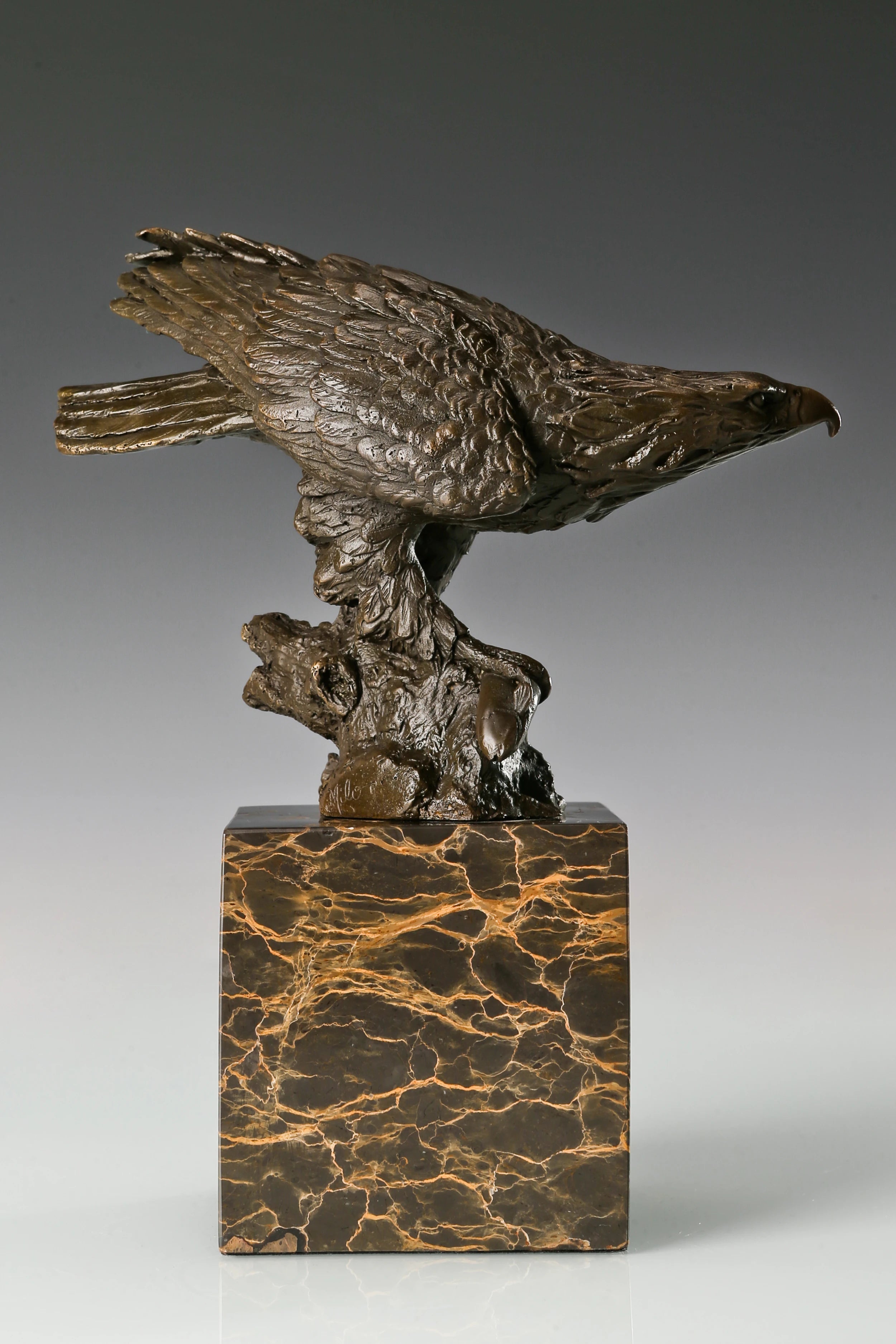 Pre-flight bronze eagle sculpture with detailed feathers and natural base. Elegant wildlife statue for home decor, office, or collectors.