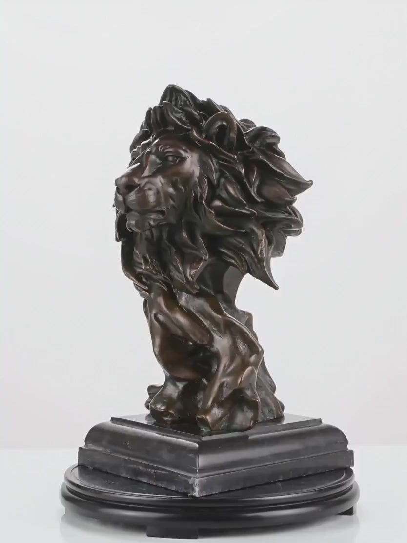 This is a powerful bronze bust of a lion, crafted using the lost-wax casting method. The sculpture focuses on the lion’s head and upper neck, capturing the animal in a moment of intense focus and regal authority. 