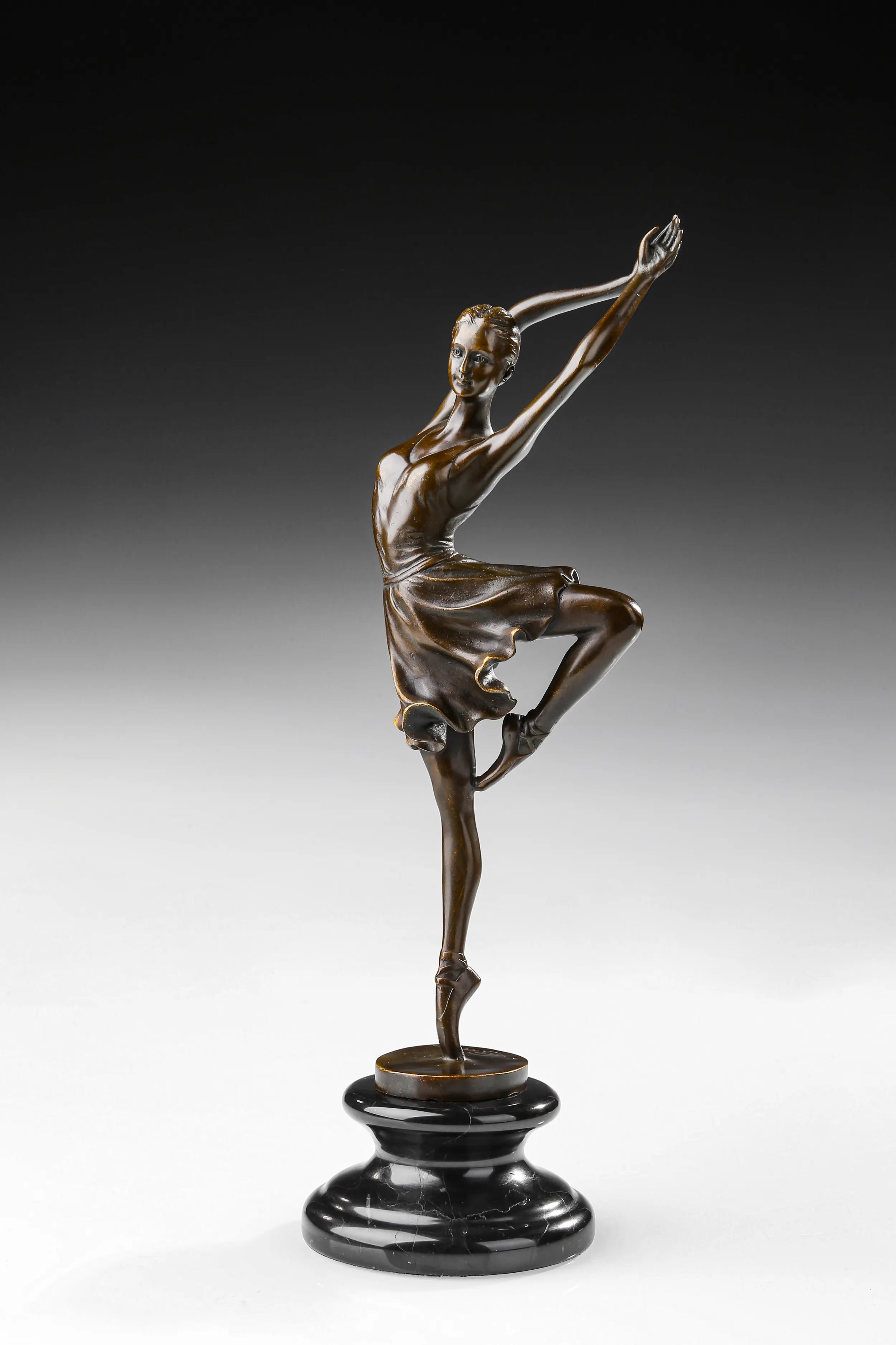 Left side view of bronze ballerina sculpture balancing with one bent leg raised