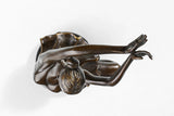 Detail of bronze ballerina with raised bent leg and gracefully lifted arms