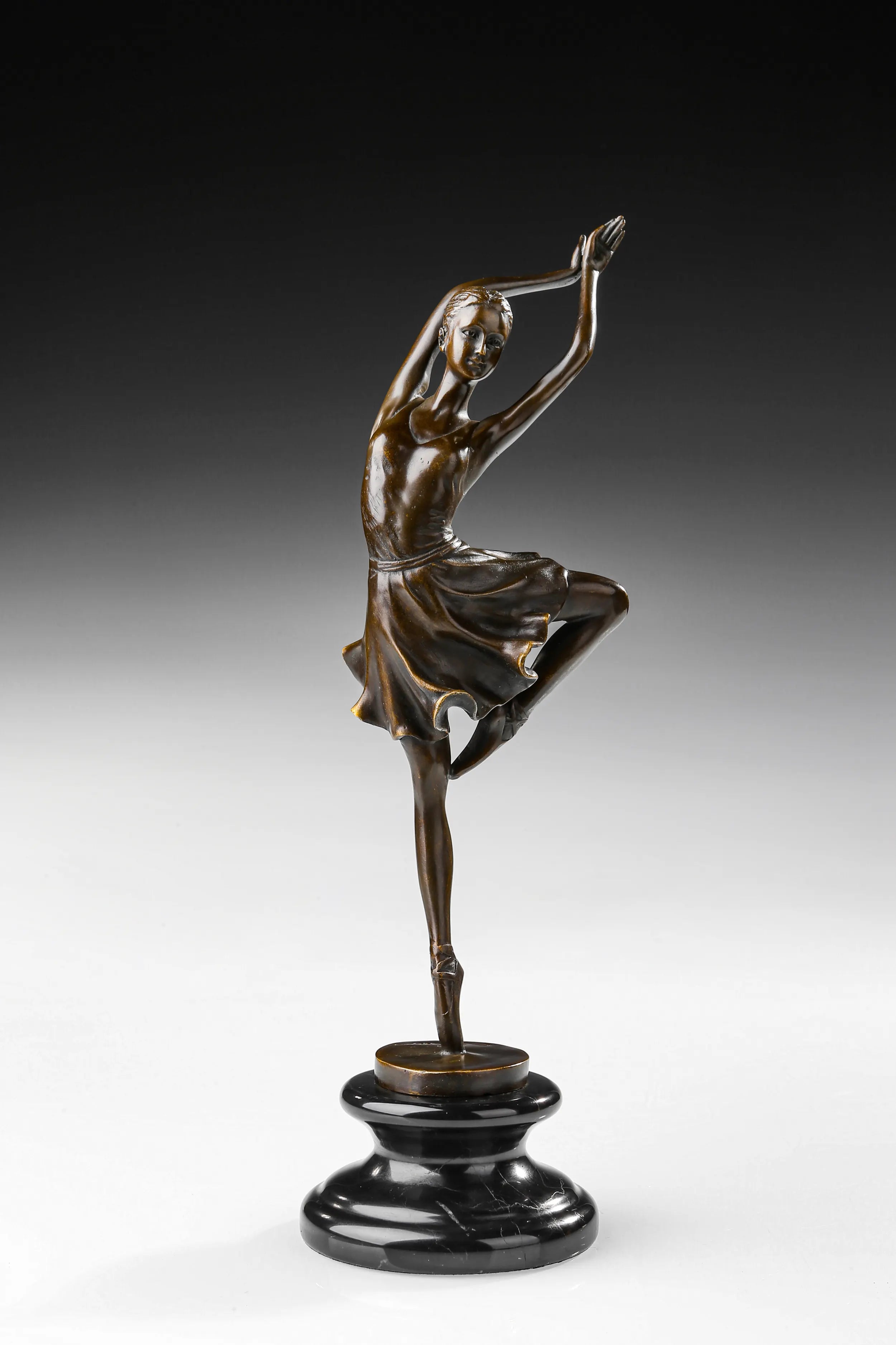Raised leg ballerina bronze sculpture standing en pointe with arms overhead