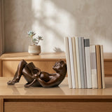 Reading cat bronze sculpture displayed in a home library or reading room