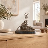 Reclining Antlered Deer bronze sculpture displayed in a minimalist interior