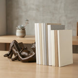 Angled view of playful reading cat bronze sculpture with glasses