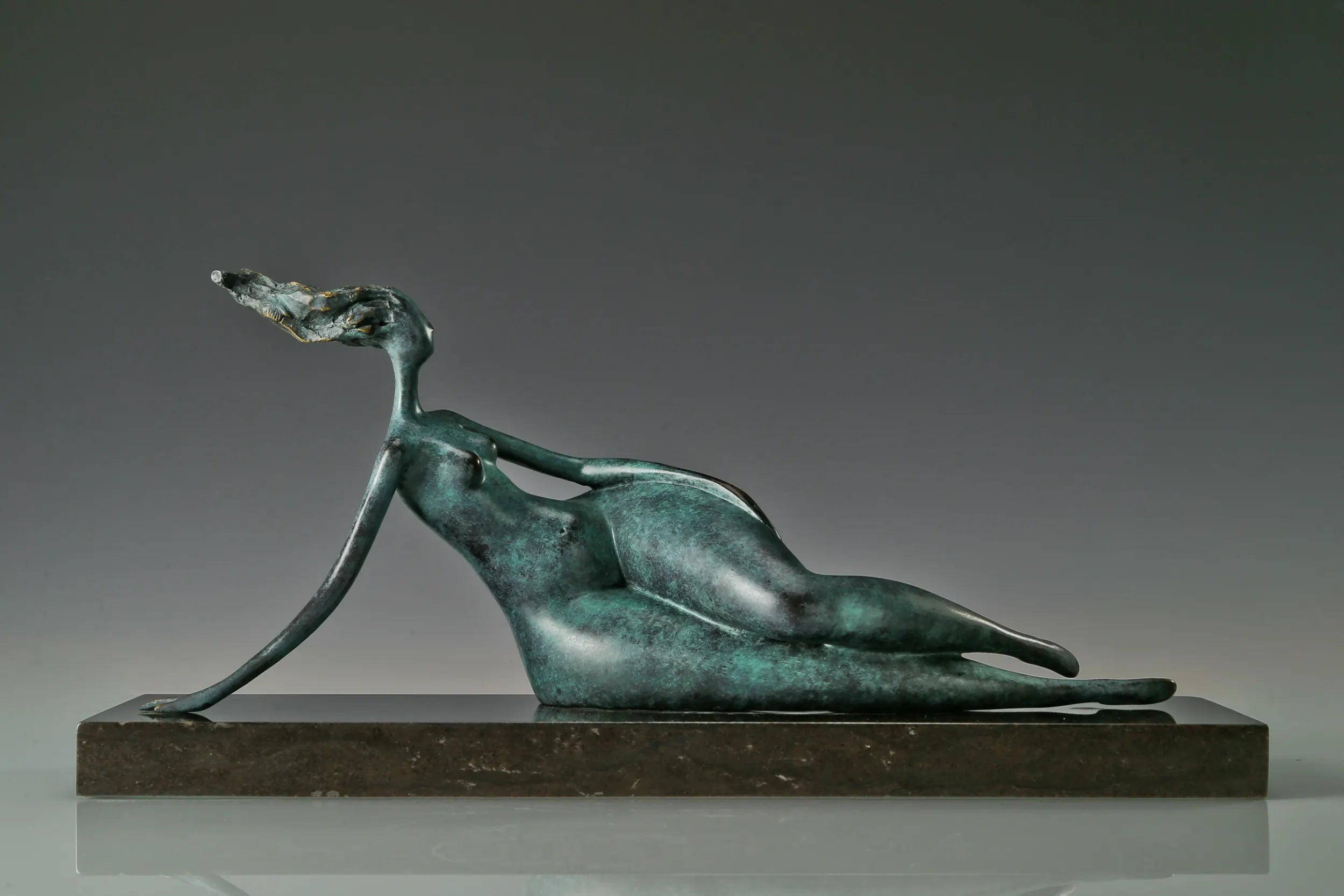 Front view of reclining female bronze statue with one arm supporting her body