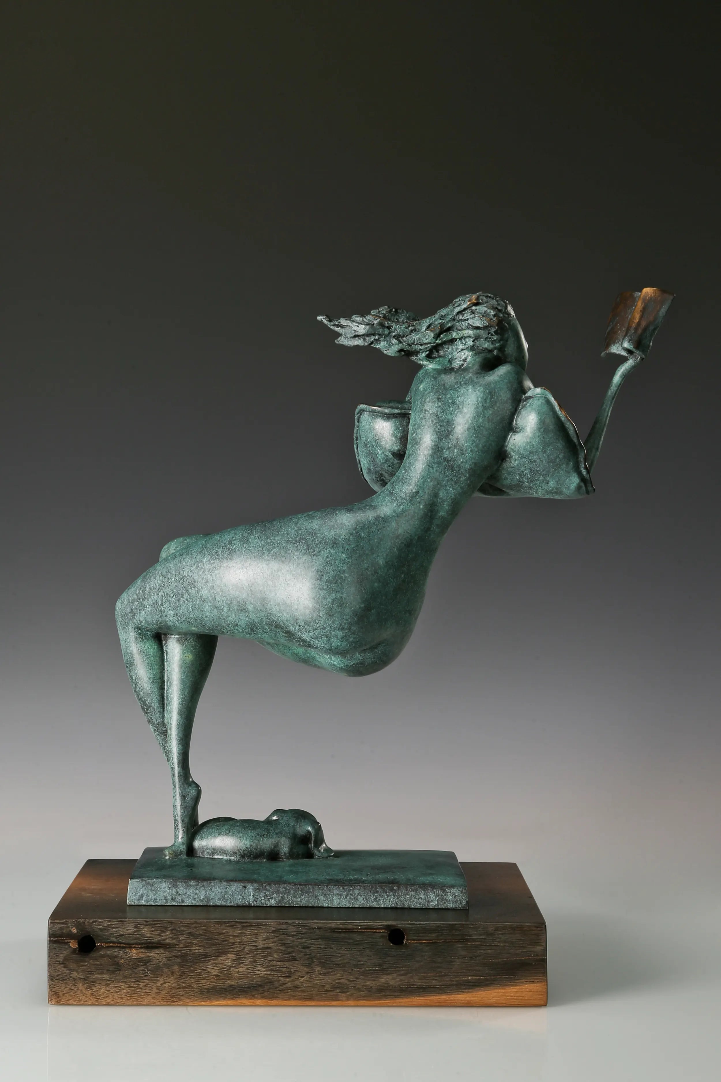 Rear view of an abstract reclining woman bronze sculpture showing her curved figure and flowing hair