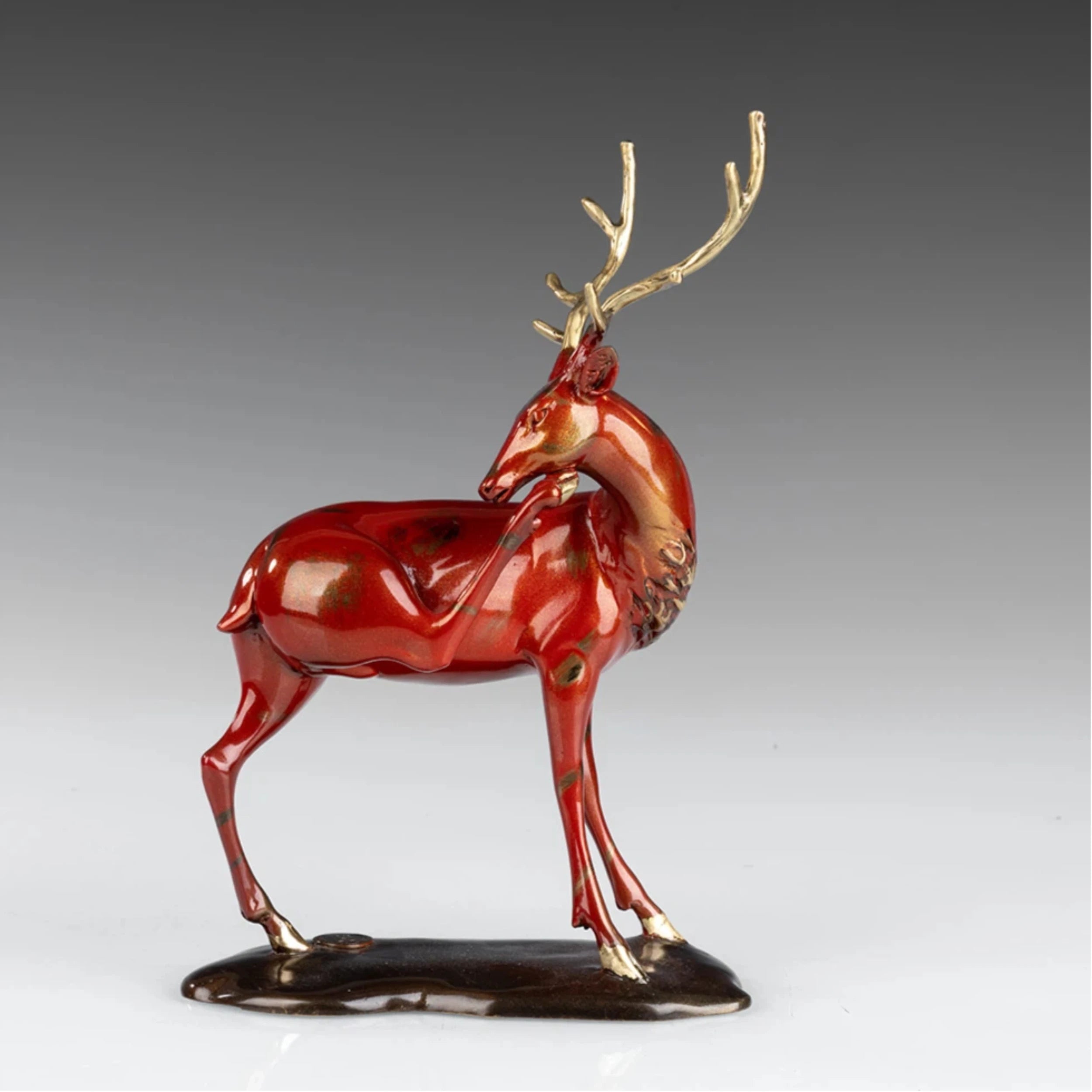 Handcrafted red bronze Christmas reindeer sculpture with elegant golden antlers