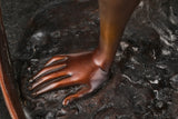 Close-up of the bronze ballet dancer's supporting hand resting on the textured base