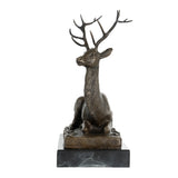 Front view of handcrafted seated bronze stag sculpture with impressive branching antlers