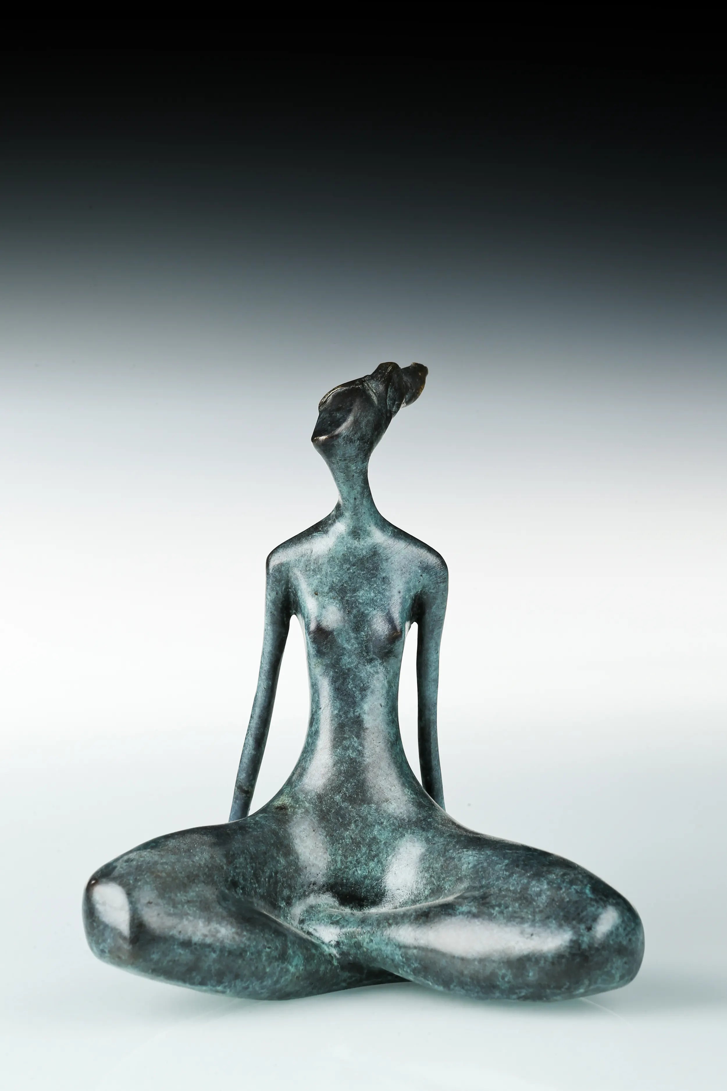Abstract female yoga statue seated cross-legged 