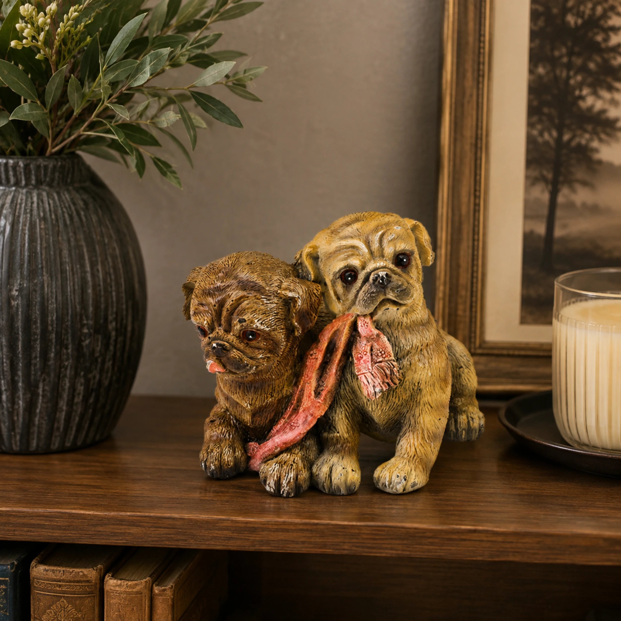 Painted bronze sculpture of two puppies holding a scarf together as cheerful home and shelf decor