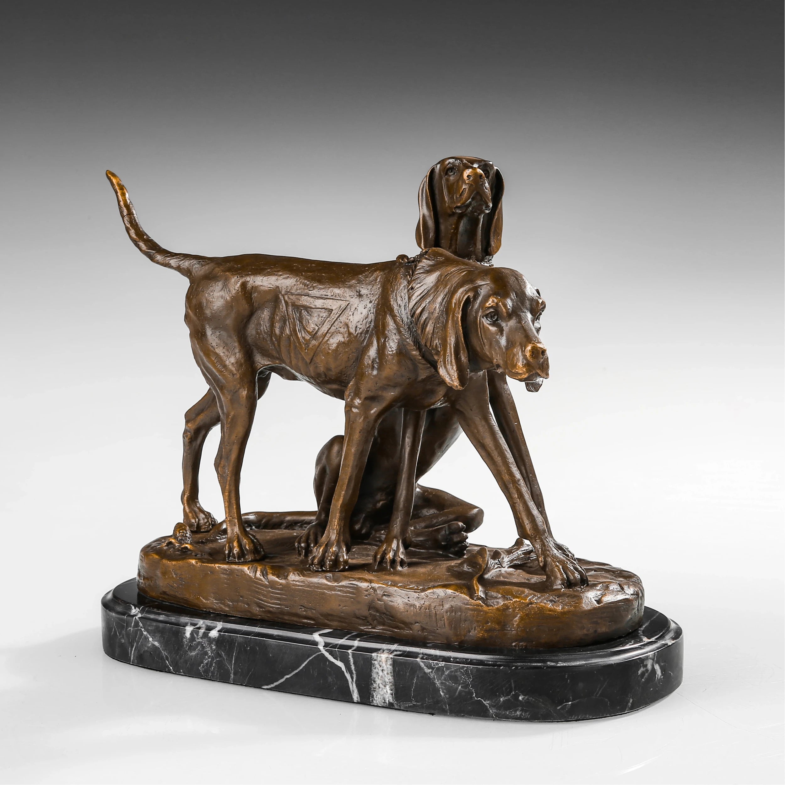 Angled view of two sporting dogs bronze sculpture showing contrasting standing and seated poses