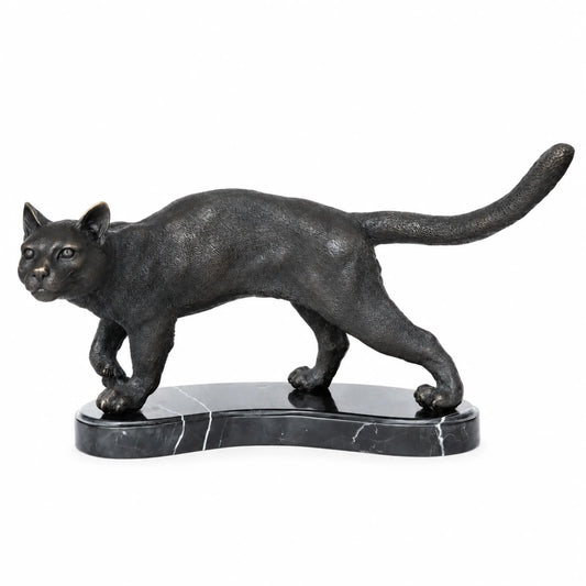 Left side view of walking cat bronze statue on marble base