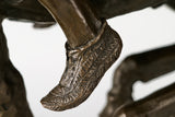 Close-up of the sculpted ground and dynamic running motion beneath the bronze horse